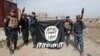 Ілюстрацыйнае фота. Іракскія сілавікі трымаюць уніз галавой на знак пагарды сьцяг групоўкі «Ісламская дзяржава», які яны садралі ў вызваленай частцы Мосулу, 27 лютага 2017 году