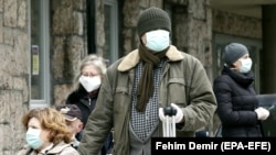 People wait for a coronavirus test outside a state hospital in the Bosnian capital, Sarajevo. 