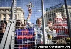 Противники протестують за поліцейським парканом під час гей-параду в Харкові, Україна