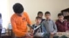 Vazgen Hovhannisian (left), a 16-year-old computer-game designer, works on a robot during a computer club meeting in the Armenian village of Aygek. 