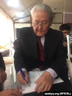 Серикболсын Абдильдин подписывает изданную им книгу. Алматы, 5 декабря 2016 года.