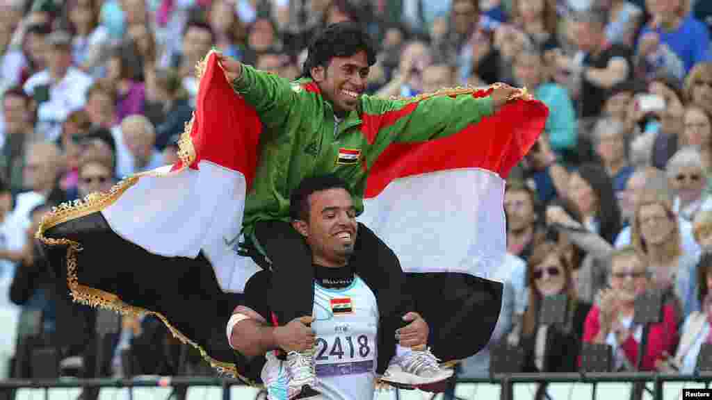 Ahmed Naas of Iraq (top) embraces Wildan Nukhailawi of Iraq after the end of a men&#39;s javelin final at the Olympic Stadium in London&#39;s Olympic Park.