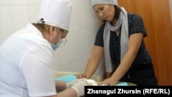 Медицинская сестра ставит прививку младенцу. Актобе, 25 января 2013 года.