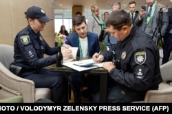 Поліція складає протокол Володимиру Зеленському, який показав бюлетень, порушивши правила голосування. Зеленському загрожує штраф. 21 квітня 2019 року