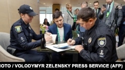 Поліцейські складають протокол на Зеленського після того, як він продемонстрував заповнений бюлетень, 21 квітня 2019 року