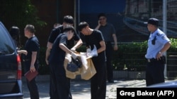Правоохранители работают на месте взрыва возле посольства США в Китае. Пекин, 26 июля 2018 года