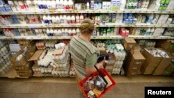 Покупательница в отделе молочной продукции супермаркета. Иллюстративное фото.