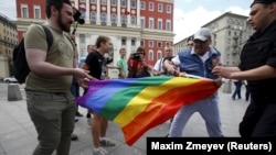 Протестующие против выступления геев пытаются отобрать у них радужный флаг. Москва, 30 мая 2015 года.