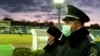 Police officers wear protective masks during a Ukrainian Premier League match.