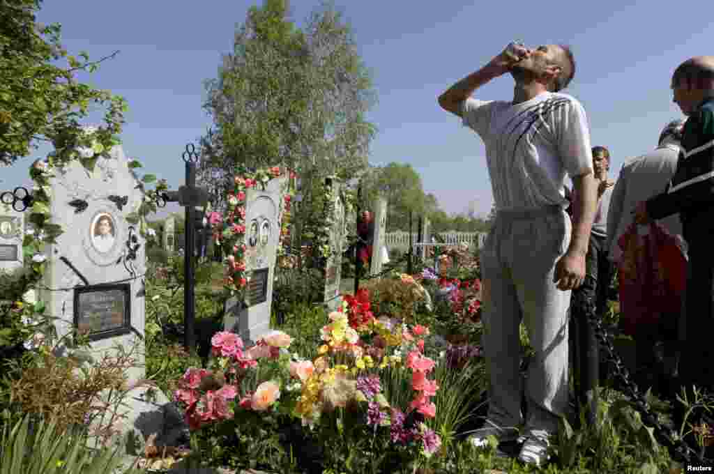 A man drinks vodka at a grave during Orthodox Easter in the Belarusian village of Pogost. Villagers in southern parts of Belarus visit their relatives' graves during Easter celebrations. (Reuters/Vasily Fedosenko)
