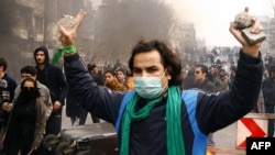 An Iranian opposition protester gestures during clashes with security forces in Tehran on December 27.