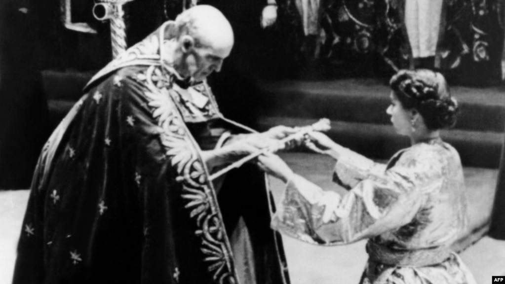  Архиепископът на Кентърбъри дава на кралица Елизабет Втора меч преди церемонията по коронясването ѝ в Уестминстърското абатство, Лондон, 2 юни 1953 година 