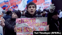 A government supporter holds a sign saying, "Russian Journalist: Don't Be A Prostitute!!!" at a pro-Kremlin rally in Moscow on December 12.