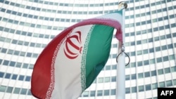 Иранский флаг перед зданием представительства МАГАТЭ. 