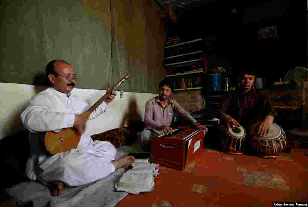 Mir Hussain Changazi (Left) from Hazara community plays Hazargi instrument Damboora, as he sings traditional songs along with Fida Hussain playing Harmonium and Zia Noorband on Tabla, as they practice at Aahanga musical academy Mariabad, Quetta, Pakistan, June 14, 2019.