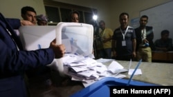 Kurdish officials empty ballots from a box after the close of polls during a disputed referendum on independence on September 25.