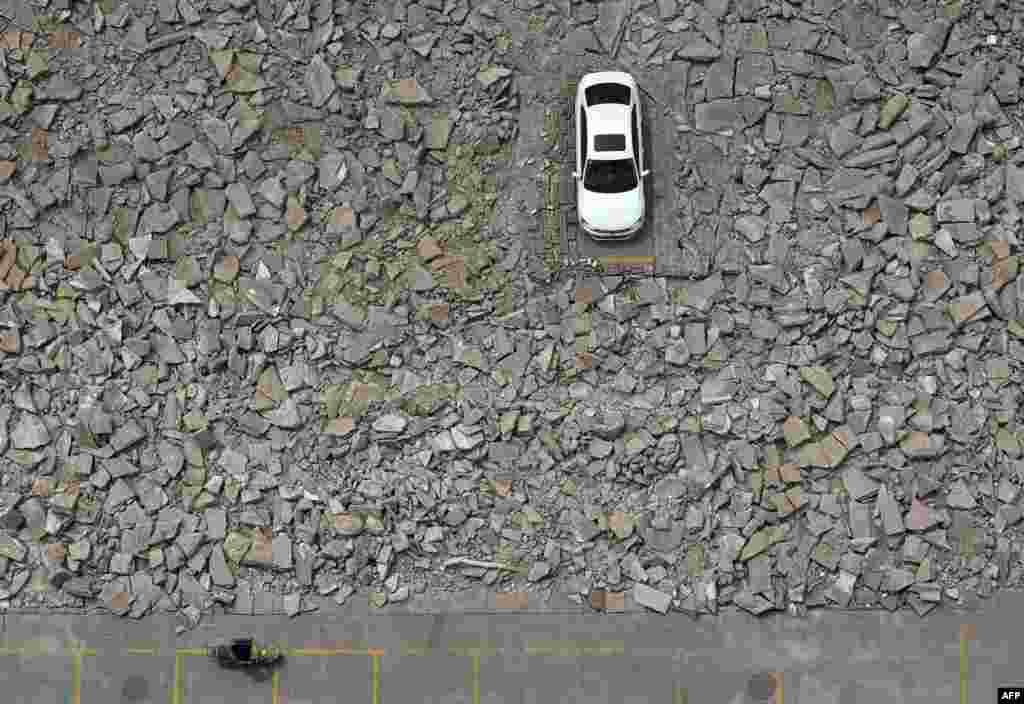 A car is surrounded by debris after construction began to widen a street in Taiyuan in China&#39;s Shanxi Province. The construction unit started working around the car after they failed to contact the owner. (AFP) 