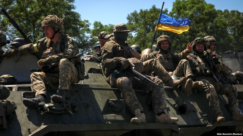 Українські військовослужбовці їдуть на бронетранспортері по дорозі на Донеччині, 7 липня 2022 року