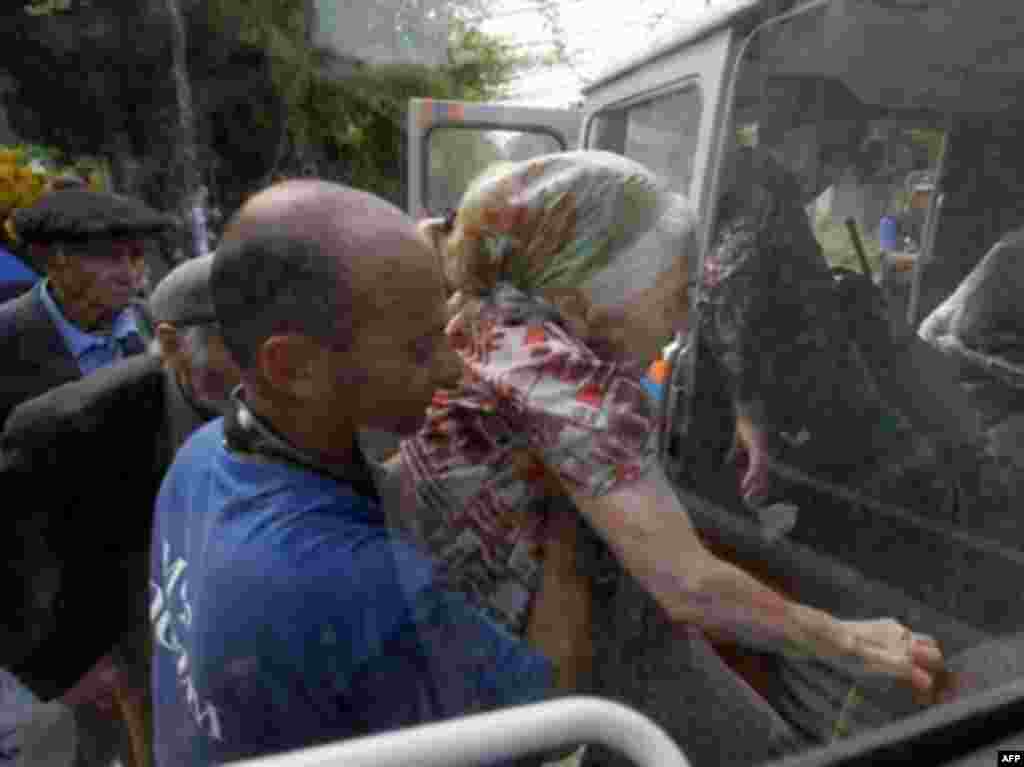 Сотрудники Министерства по черезвычайным ситуациям РФ помогают 98-летней Негне Пехшвелашвили эвакуроваться из деревни Кхейти близ Цхинвали, 21 августа 2008