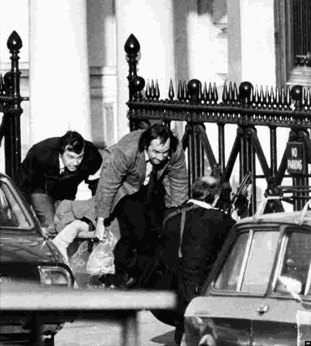Pengmarrësit kanë qenë të zemëruar se sa pak është bërë në plotësimin e kërkesave të tyre, andaj më 5 maj të vitit 1980, ata kanë vrarë zyrtarin për shtyp të ambasadës, Abbas Lavasani. Ata kanë hedhur trupin e tij nga dritarja dhe kanë kërcënuar me vrasje të pengjeve për çdo gjysmë ore, derisa të miratohen të gjitha kërkesat e tyre. Në këtë kohë, Qeveria britanike ka vendosur që të veprojë shpejt dhe ka urdhëruar komandantët e forcave elite që të hyjnë në ambasadë. Në këtë fotografi, dy burra bartin trupin e Lavasanit, para se të nisin shpërthimet në ndërtesë.