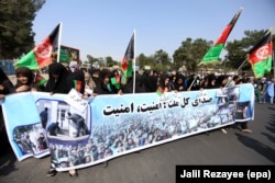 In a protest in the western Afghan city of Herat, members of the Hazara community hold a banner reading in Dari 'the whole nation calls for Peace' as they rally to demand the government to bring security and stability to the country.