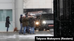 Members of the British Embassy staff applaud as a convoy of vehicles leaves its compound in Moscow on March 23.