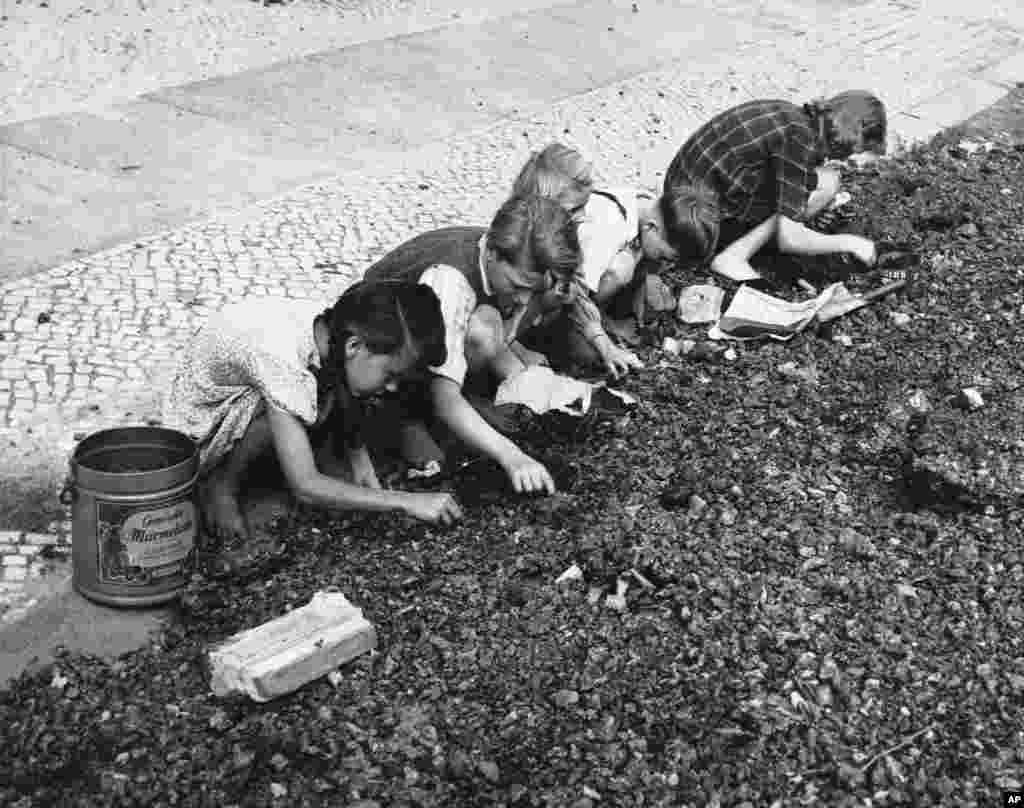 Copii adunînd bucăți de cărbune în afara unei uzine vest-berlineze (27 august 1948). Livrarea de combustibil a constituit un element crucial în timpul podului aerian pentru a menține în operație fabricile și facilitățile industriale.