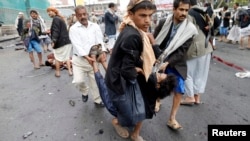 Njerëzit u ndihmojnë të plagosurve nga sulmi i sotëm në kryeqytetin Sana në Jemen