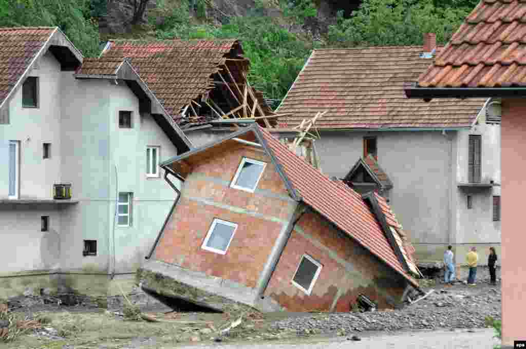 People stand near damaged houses after flooding in Krupanj, 150 kilometers southeast of Belgrade, Serbia. (Reuters/Srdjan Zivulovic)