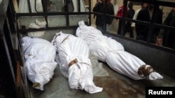 Тела погибших при обстреле сирийского города Хомс