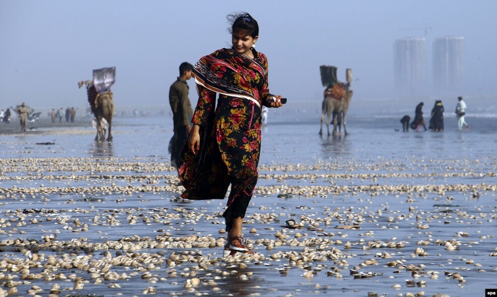 Një vajzë mbledh guaca deti në plazh në qytetin port, Karaçi, Pakistan.