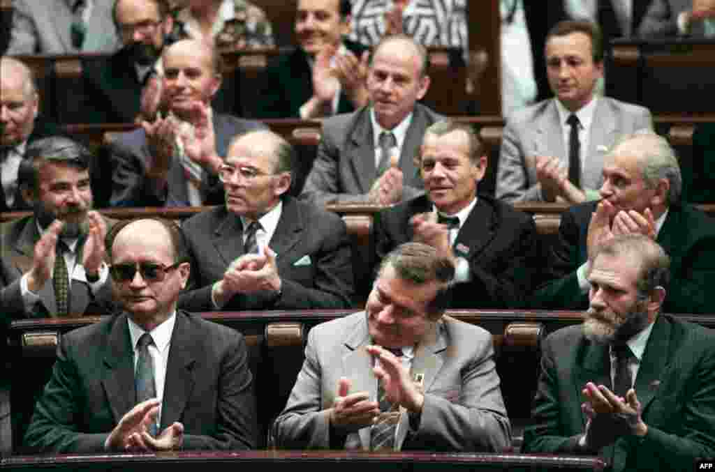 Jaruzelski, Solidarity leader Lech Walesa, and Solidarity adviser Bronislaw Geremek (front row, left-to-right) applaud during the first meeting in 50 years of Poland's parliament, the Diet, in Warsaw on July 4, 1989.