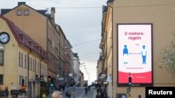 Covid-ті таратпаудағы әлеуметтік арақашықтықтың маңызын айтқан, үй қабырғасына ілінген жарнама. Стокгольм, Швеция. 29 сәуір, 2020 жыл.