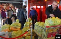 Voluntari distribuind hrană oferită de Rinat Ahmetov în Donețk.