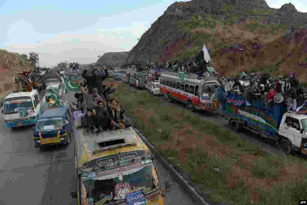 Supporters of Pakistani religious leader Muhammad Tahir-ul-Qadri takes part in a protest march in Sohawa, about 80 kilometers from the Pakistani capital, Islamabad. Tens of thousands of Pakistani protesters streamed toward Islamabad, led by a cleric calling for revolution but accused of trying to sow political chaos ahead of elections. (AFP/Farooq Naeem)