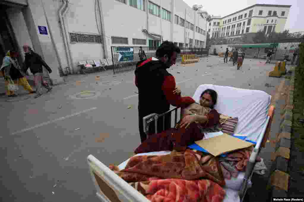 A relative takes care of a patient on a bed after she was taken out of her ward when a group of Pakistani lawyers stormed the Punjab Institute of Cardiology in Lahore on December 11. (Reuters/Mohsin Raza)