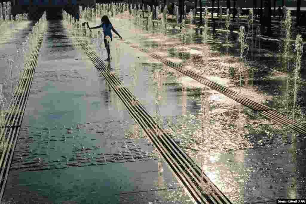 A child cools off in a fountain during warm weather in Moscow&#39;s Gorky Park. (AFP/Dimitar Dilkoff)