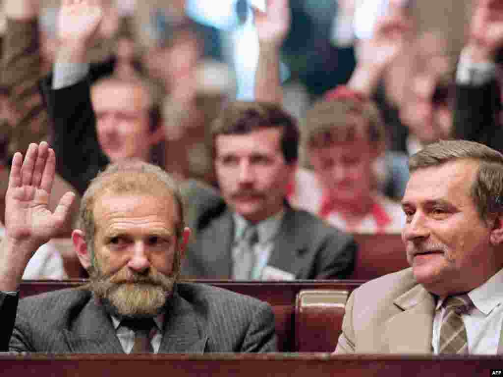 Walesa looks on as Bronislaw Geremek, a Polish academic who played a key role in the Round Table Agreement, raises his hand during the inaugural session of the Polish parliament's first multiparty session in history, on July 4, 1989. Geremek was a member of the lower house of parliament, the Sejm, and went on to serve as foreign minister from 1997-2000. 