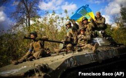 Украинские военные на БТР едут по дороге между Изюмом Харьковской области и городом Лиманом Донецкой области, 4 октября 2022 года
