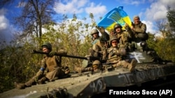 Украинские военные на БТР едут по дороге между Изюмом Харьковской области и городом Лиманом Донецкой области, 4 октября 2022 года