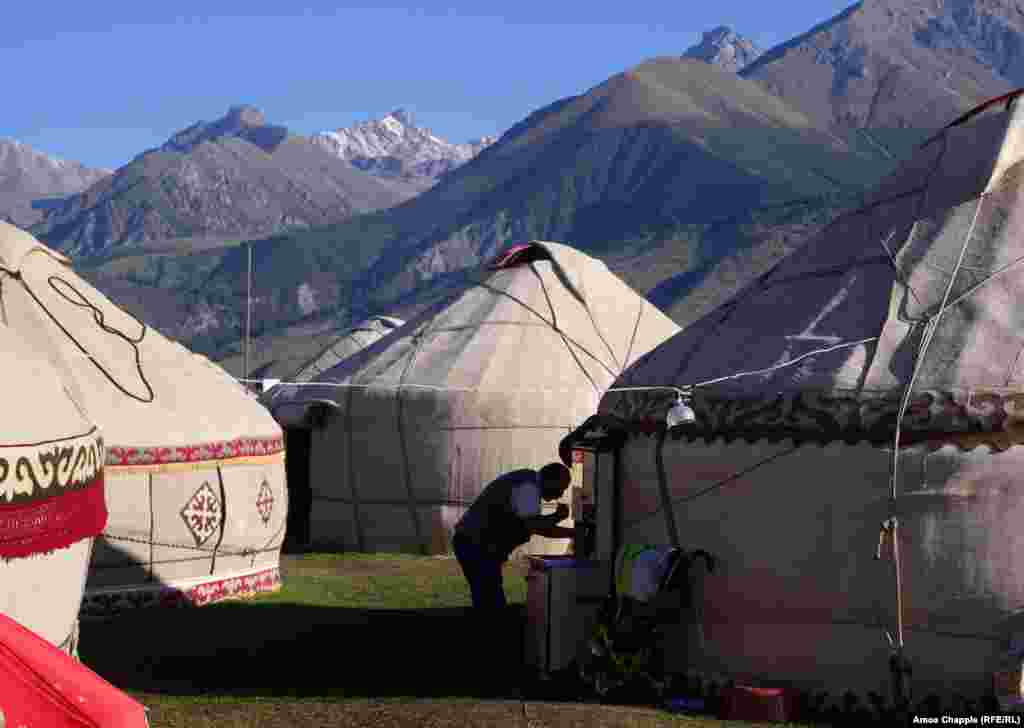 Житель табору Ігор, що складається зі споруджених за старовинними правилами юрт, чистить зуби на світанку на тлі гір Тянь-Шань