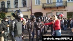 Арнайы жасақ қызметкеріне Беларусь Конституциясын ұсынып тұрған демонстранттардың бірі. 