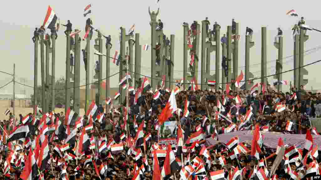  Ирак: АҚШ-тың Ирактан әскерін алып кетуіне байланысты ұйымдастырылған арнайы шарада шииттік дінбасы Мухтада әл-Садрдың жақтастары ұлттық туларын желбіретіп тұр. Бағдад, 9 ақпан, 2012 жыл. 