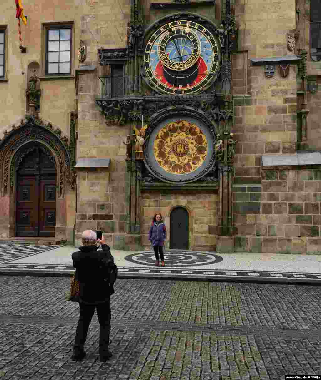 Чешская пара фотографируется перед знаменитыми астрономическими часами в Праге