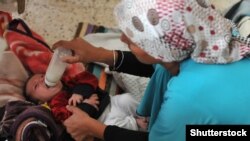 Сирийская мать кормит ребенка в Турции. Иллюстративное фото
