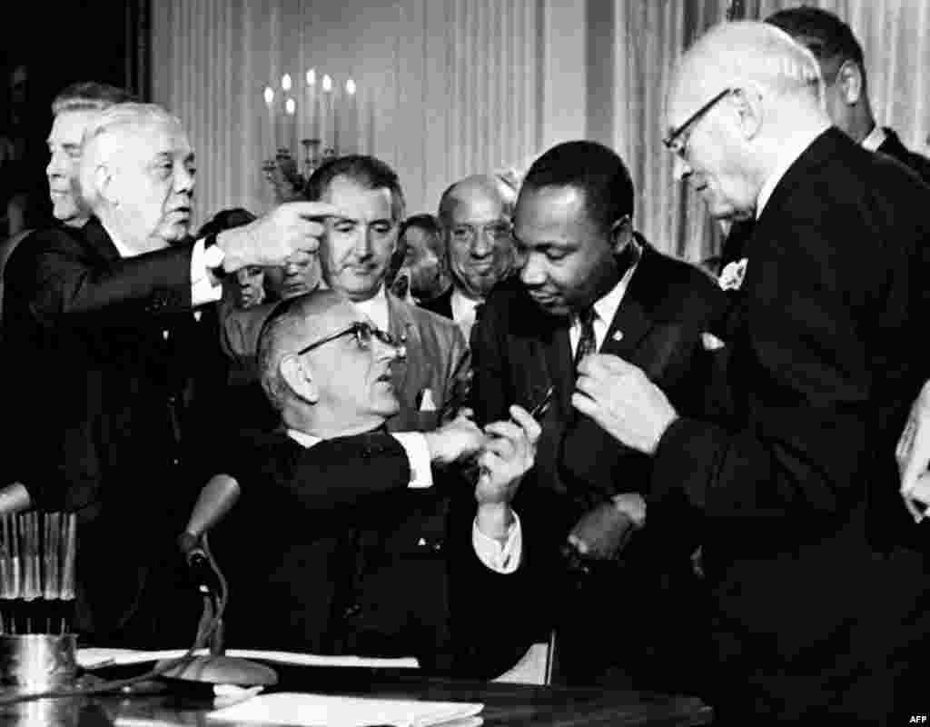 U.S. President Lyndon B. Johnson shakes hands with Dr. Martin Luther King Jr. after signing the historic Civil Rights Bill in the White House on July 2, 1964.