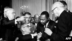 Martin Luther King (i dyti djathtas) me presidentin Lyndon Johnson (i dyti majtas) në Uashington në vitin 1964 