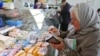 Belarus -- A woman counts her money as she buys a piece of cheese at a city market in Minsk, 25May2011