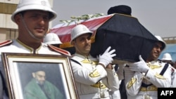 An honor guard carries the coffin of Abdul Aziz al-Hakim upon its arrival at Baghdad International Airport.