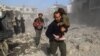 Сирийцы среди развалин домов вблизи Дамаска 